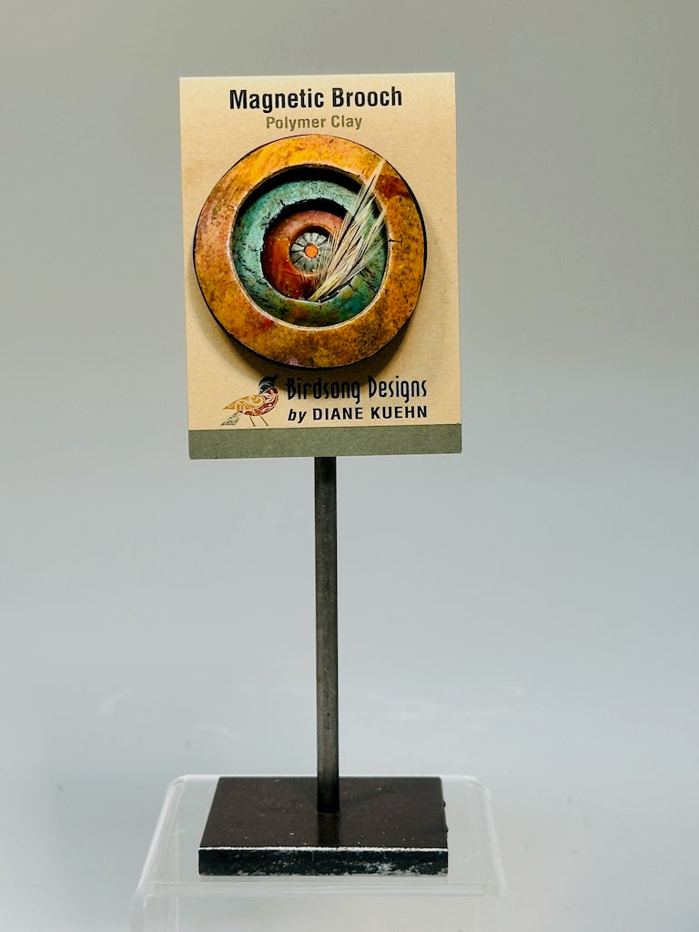 CONCENTRIC POLYMER CLAY BROOCH WITH SWAROVSKI CRYSTAL CENTER AND FEATHER ACCENT PCB867