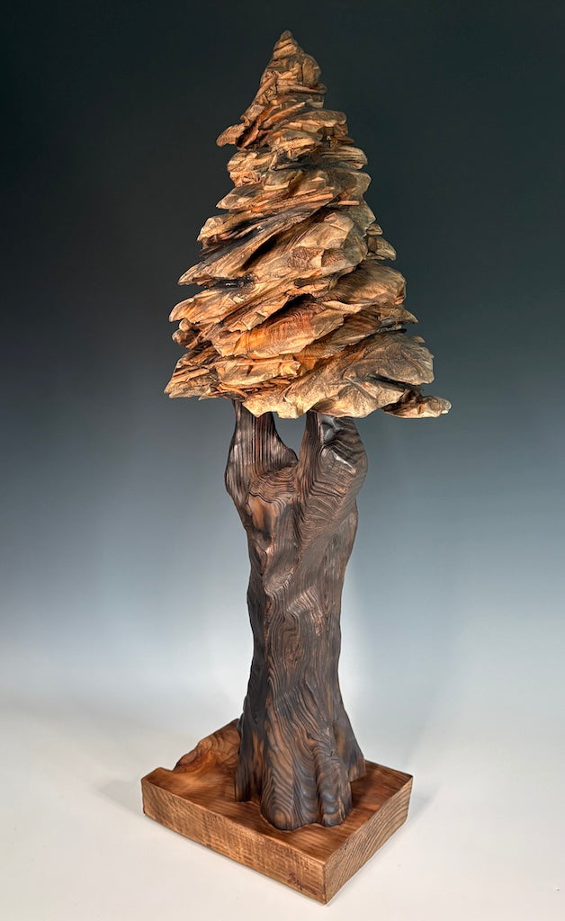 "SOLITUDE" WHITE PINE, GRAPHITE AND LEYLAND CYPRESS WOOD SCULPTURE
